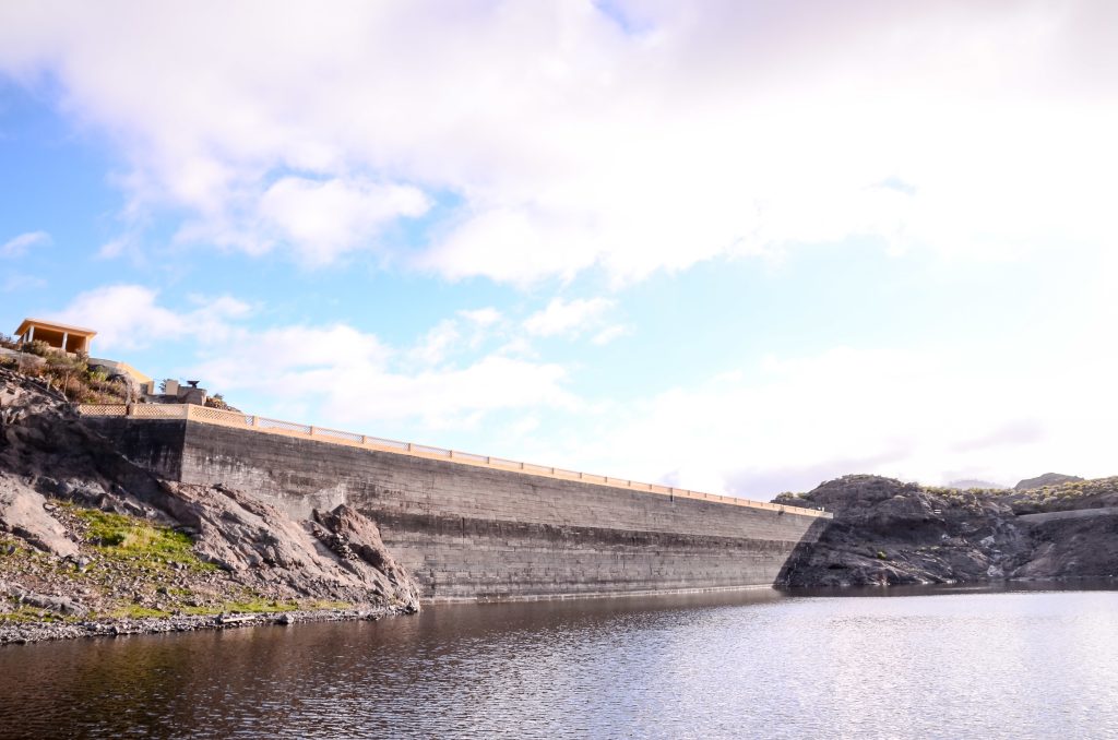 Lake water dam in canary islands in spain with a cloudy blue sky in the background
